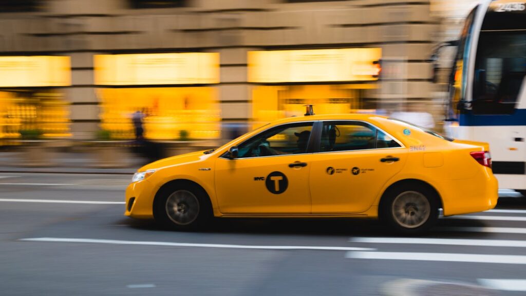 zipwp-image-462867 A New York City yellow taxi speeds through urban streets, capturing the bustle of city life.